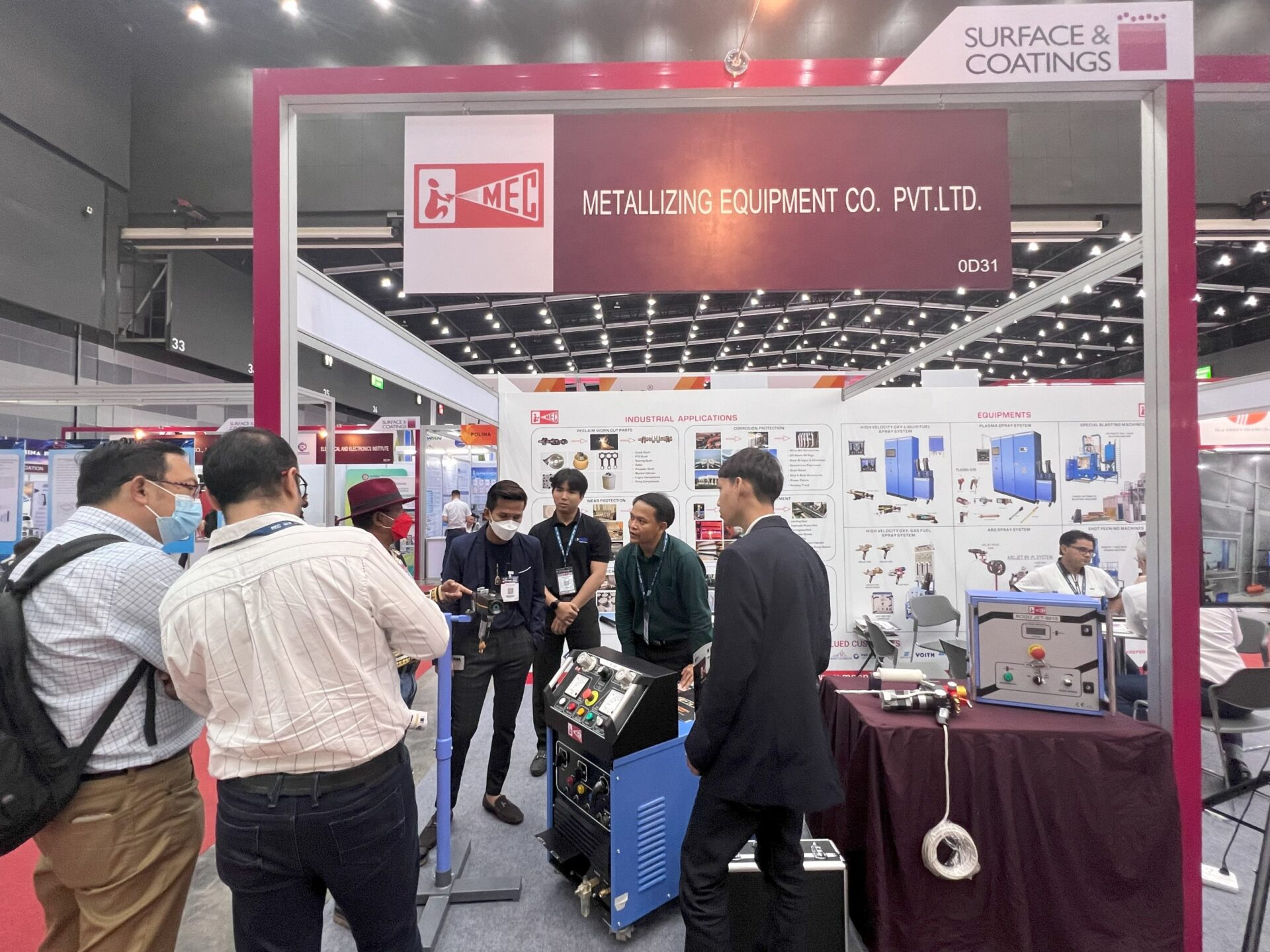 ผู้เข้าชมงานยืนฟังทีมงานอธิบายเครื่องพ่นลวดอาร์ก Arc Spray ที่บูธ MEC 0D31 งาน Surface & Coatings 2023